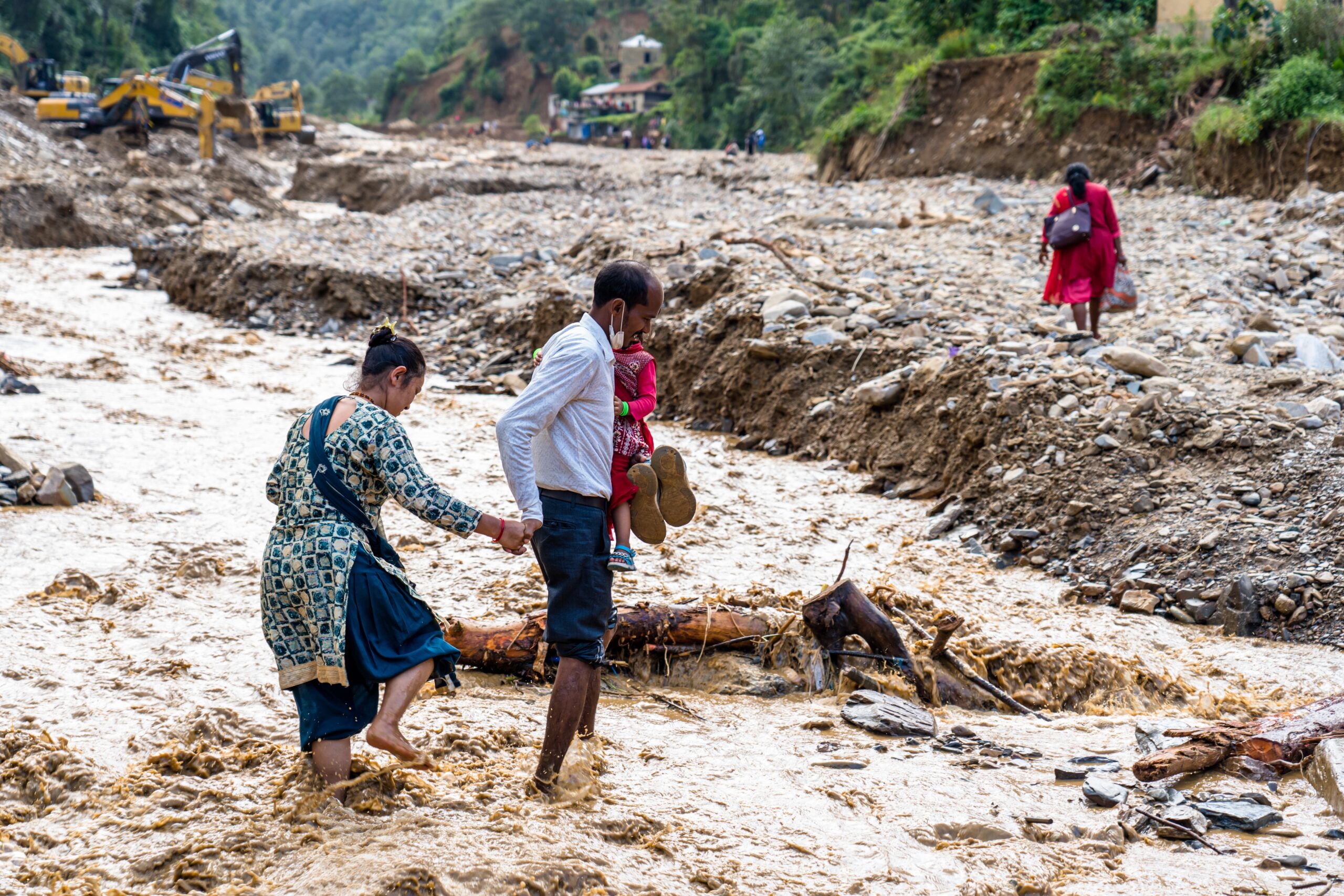 Representative photograph of residents navigating flood-damaged terrain in Nepal